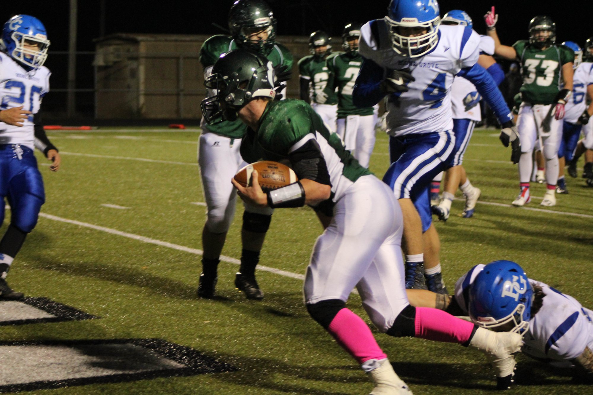 A Whiting ball carrier braces against a defender near the sideline.