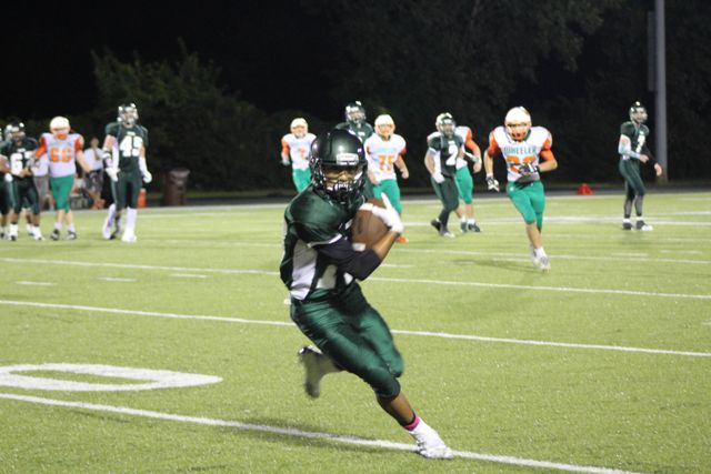 A Whiting ball carrier cuts toward the camera with defenders behind him.