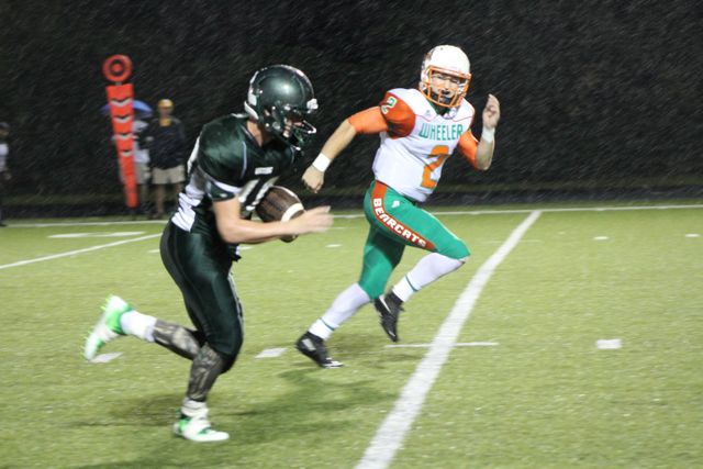 A Whiting runner turns upfield near an orange-and-green defender.