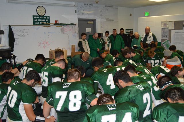Players gather closely in the locker room before a team talk.