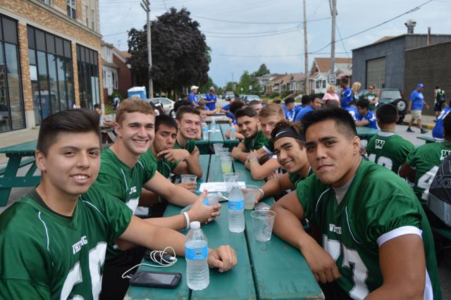 Whiting players share a long outdoor table at a community gathering.
