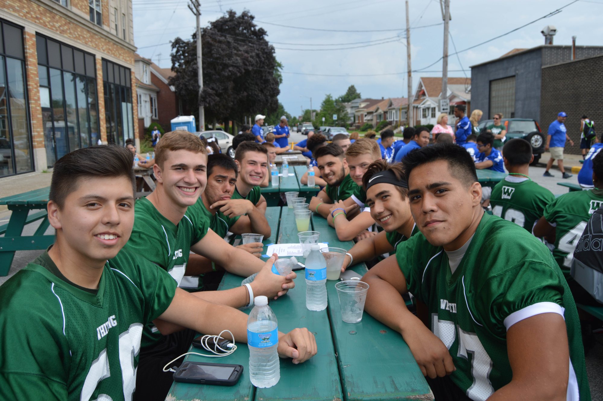 Whiting players share a long outdoor table at a community gathering.