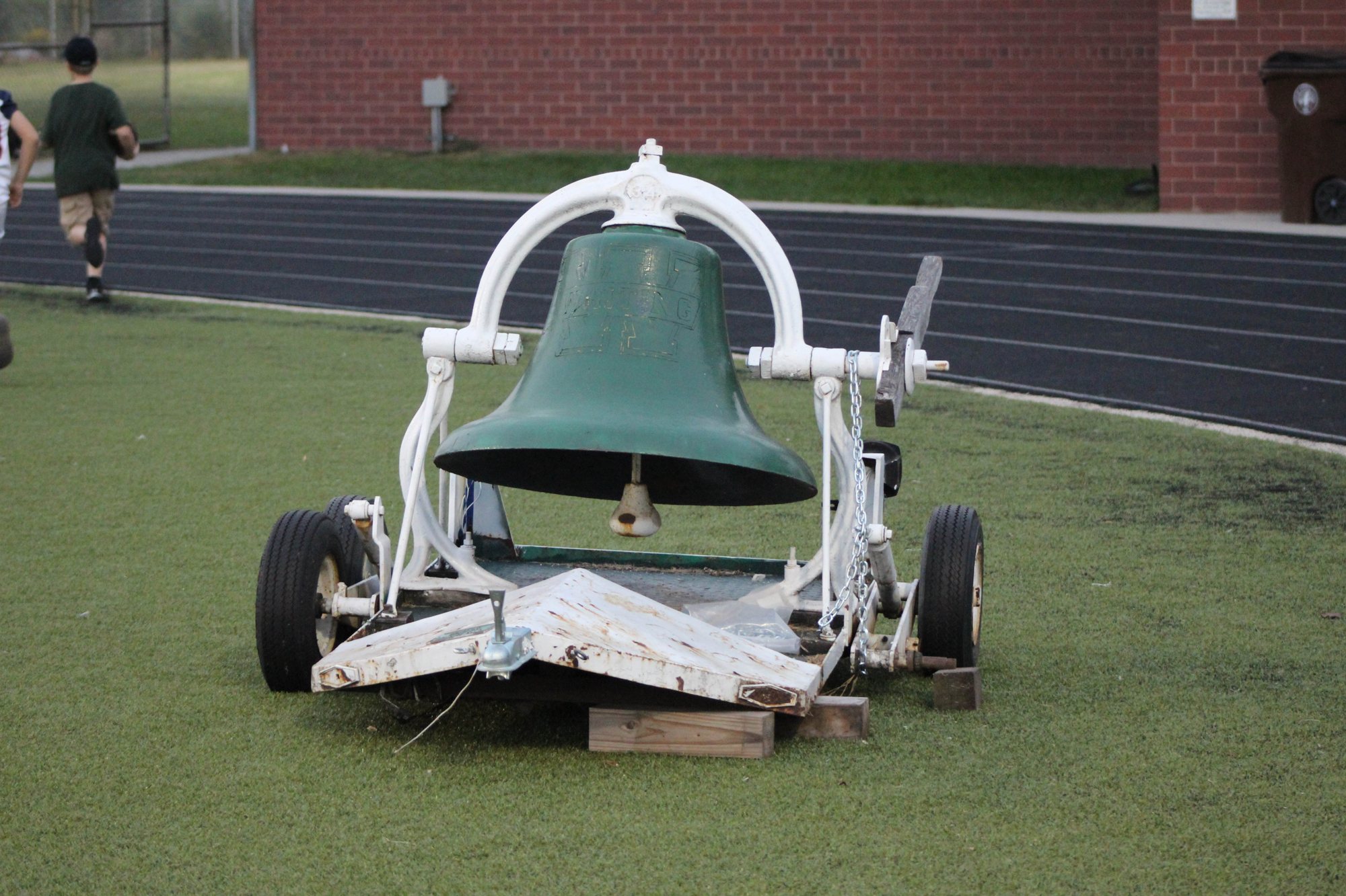 The green bell sits beside the field before a game.