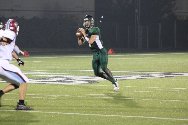 A Whiting quarterback sets to throw under the lights.