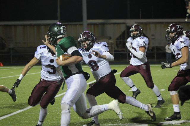 A Whiting player drives forward against defenders in white and maroon.