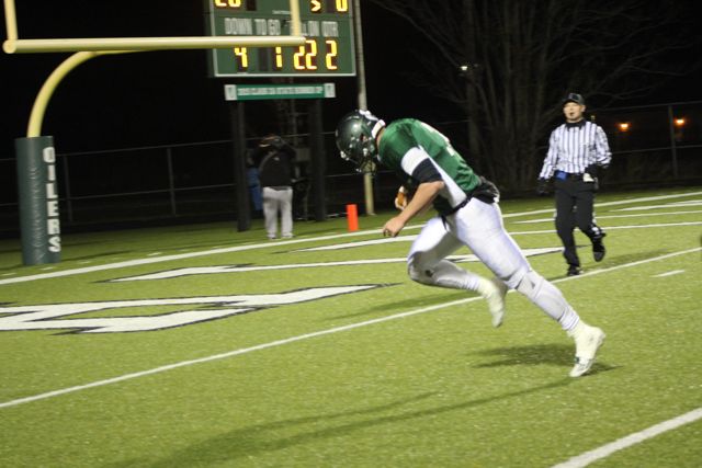 A Whiting runner leans forward with the ball near the end zone.