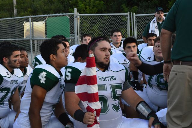 Players listen closely during an outdoor team talk.
