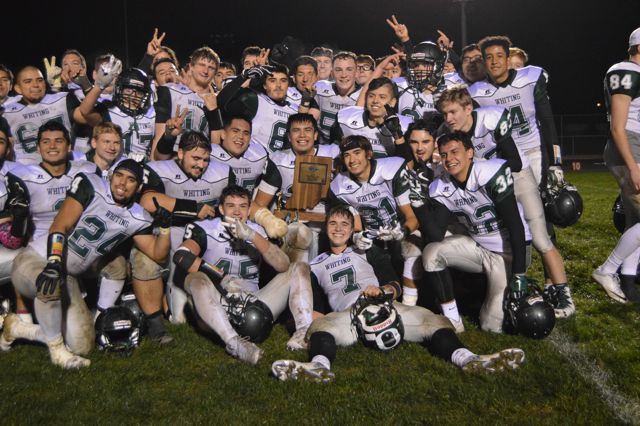 Whiting players in white pose closely together with a trophy.