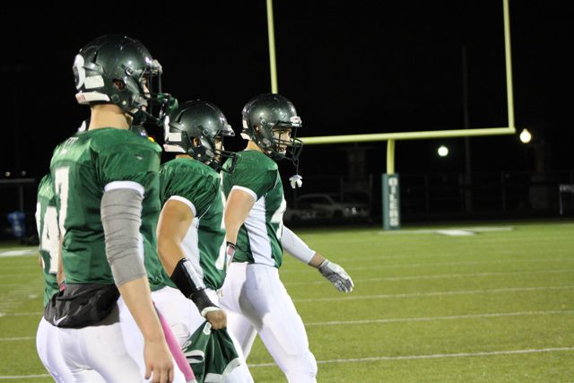 Whiting players stand together near the end zone.